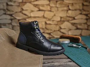 Detailed side view of men's vintage black leather Martin boots with metal eyelets