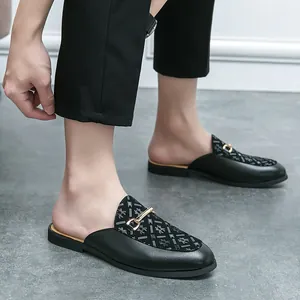 Mules de cuero negro para hombre con elegante estampado de arañas y hebilla dorada