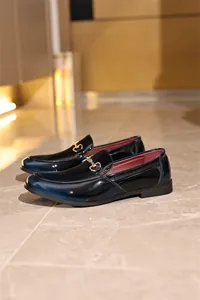 Detailansicht der dunkelblauen Lackleder-Loafer mit klassischem Metall-Gebiss-Ornament
