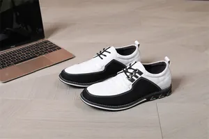 Vista dettagliata scarpe casual da uomo bianche e nere traspiranti su legno