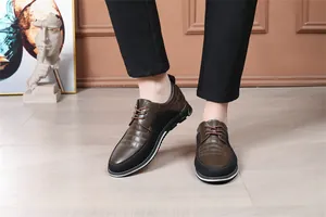 Dettaglio di scarpe casual da uomo in pelle marrone e nera con lacci indossate in interni.