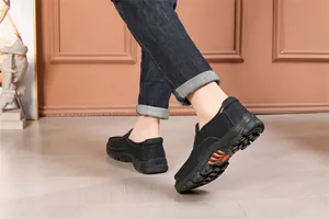 Side view of comfortable black men's casual slip-on leather shoes with durable thick soles.