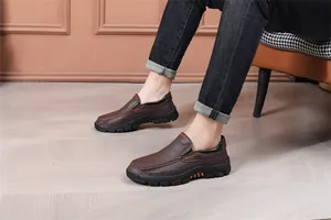 Detail of brown pebbled leather loafers with slip-on design and thick black rubber sole.