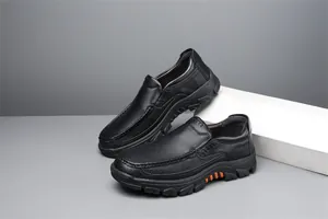 Detail of black leather men's slip-on loafers with textured cowhide and thick sole.
