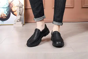 Close-up detail showing the textured leather and stitching of men's black slip-on shoes