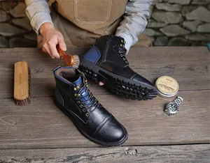 Detailed view of person cleaning retro leather Martin boots with a professional brush