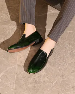 Close-up of glossy dark green leather loafers for men in a formal business setting
