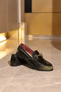 Detailansicht von Herren-Lack-Loafern mit grünem Farbverlauf und Metallschnalle.