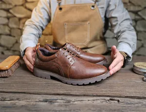 Nahaufnahme von braunen Vintage-Derby-Schuhen aus Leder in einer rustikalen Handwerkstatt