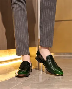 Detailed view of luxury men's dark green patent leather loafers with gold-toe trim.