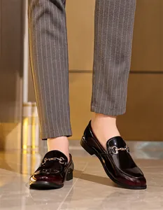 Nahaufnahme von Herren-Loafers in Burgund mit Metallbit und Nadelstreifenhose