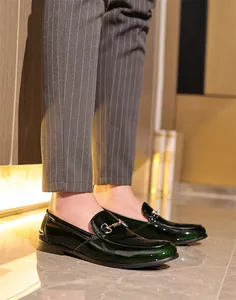 Nahaufnahme von eleganten dunkelgrünen Herren-Loafers aus Lackleder im britischen Stil