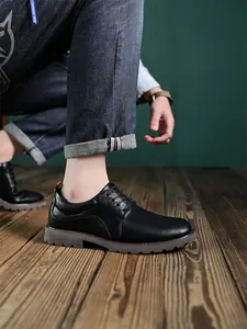 Detailaufnahme von klassischen schwarzen Herren-Derbyschuhen mit robuster Gummisohle.