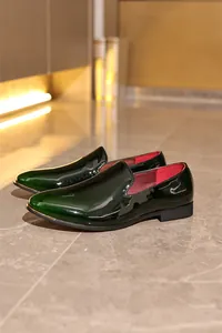 Side view showing details of elegant high-gloss green patent leather men's loafers