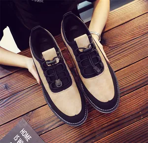 Detailed top-down view of khaki and black casual men's loafers on wooden background
