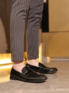 Detailansicht von schwarzen Lackleder-Loafern für Herren mit formeller Nadelstreifenhose