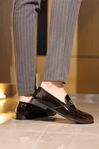 Nahaufnahme von glänzenden Lackleder-Loafers für Herren mit klassischer Metallschnalle