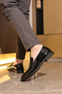 Nahaufnahme eleganter Herren-Loafer aus schwarzem Lackleder in formellem Rahmen