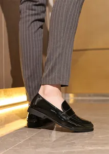 Detailansicht eleganter schwarzer Lackleder-Loafer zu einer gestreiften Hose für Herren