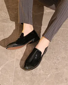 Close-up of black patent leather loafers with metallic toe detail for men