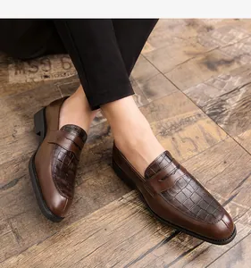 Détail de mocassins marron pour hommes avec empiècement en cuir texture crocodile