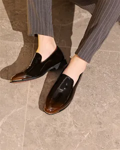 Close-up detail of high-gloss dark brown men's formal loafers with gold trim