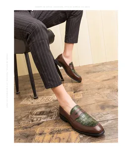 Gros plan de mocassins rétro en cuir marron pour hommes avec motif crocodile vert