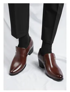 Détail de chaussures en cuir marron pour hommes avec talon cubain et bout pointu