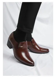 Détail de chaussures habillées à talon cubain marron à bout pointu avec logo.