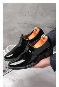 Gros plan de chaussures pour hommes en cuir verni noir à talon cubain et bout pointu
