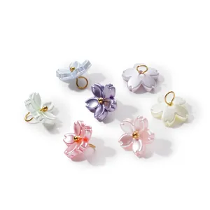Detailed close-up of iridescent pearlescent cherry blossom pendants for DIY jewelry crafts