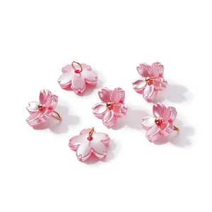 Close-up detail of iridescent pink ABS pearl cherry blossom pendants for DIY jewelry