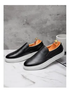 Vista detallada de mocasines negros para hombre con diseño minimalista y suelas blancas de goma
