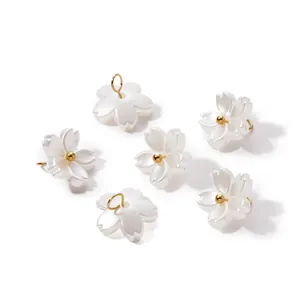 Detailed macro view of pearlescent ABS flower charms with gold loops for DIY crafts