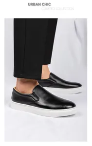 Vista detallada de los mocasines de cuero negro para hombre con suelas blancas gruesas.