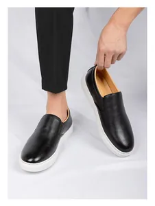 Vista detallada que muestra la textura de cuero negro premium de los mocasines de hombre