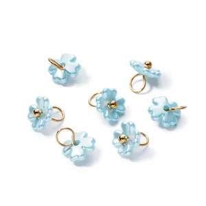 Detailed view of iridescent light blue ABS pearl flower pendants for DIY jewelry crafts
