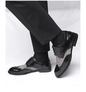 Klassische Brogue-Schuhe aus schwarzem Leder mit Karostoff am Modell präsentiert.