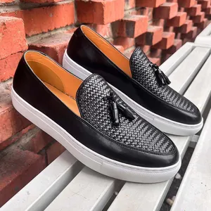 Mocasines de cuero negro para hombre con borlas, textura tejida y suela blanca