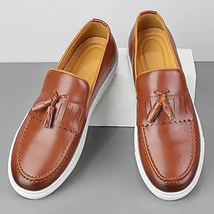 Elegantes mocasines con borlas marrones para hombre con suela de plataforma blanca.