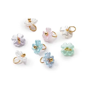 Close-up of pearlescent ABS flower charms with hanging rings for DIY jewelry making