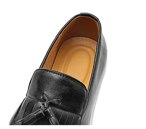 Dettaglio dei mocassini da uomo in pelle nera stile inglese con eleganti nappine decorative