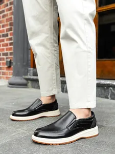 Detailed side view of black leather business casual loafers with contrasting white soles