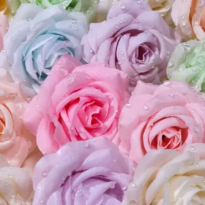 Primo piano di teste di rose artificiali colorate con gocce di rugiada su petali di seta.