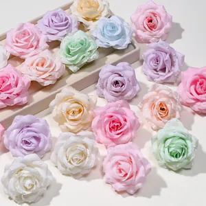 Dettaglio di testine di rose artificiali in seta con effetto rugiada in tonalità pastello