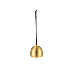 Close-up view of a minimalist matte brass bell pendant with a black hanging cord for DIY