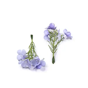 Dettaglio ravvicinato di piccoli fiori artificiali viola per accessori per capelli