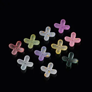 Detailed view of translucent acrylic four-petal flowers with gold foil for DIY jewelry.