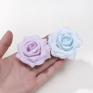 Primo piano di teste di rose in seta con gocce d'acqua per decorazioni DIY.