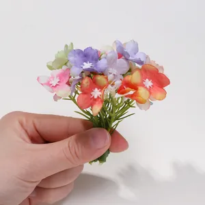 Dettaglio di piccoli fiori artificiali di seta multicolore per accessori per capelli.